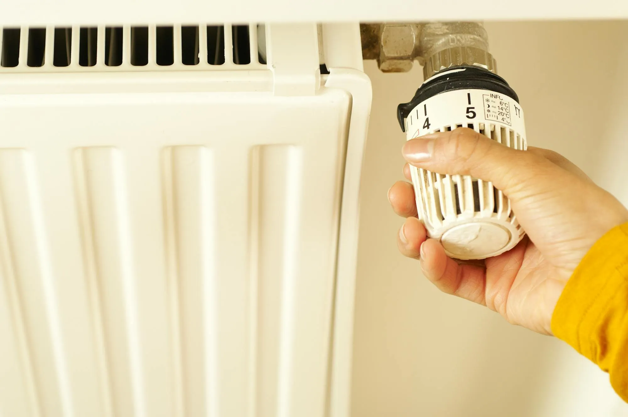 Hand adjusting a thermostatic radiator valve in a Bradford home